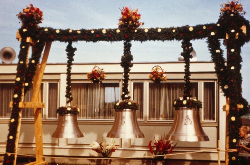 Glocken auf einem Gestell vor der Kirche